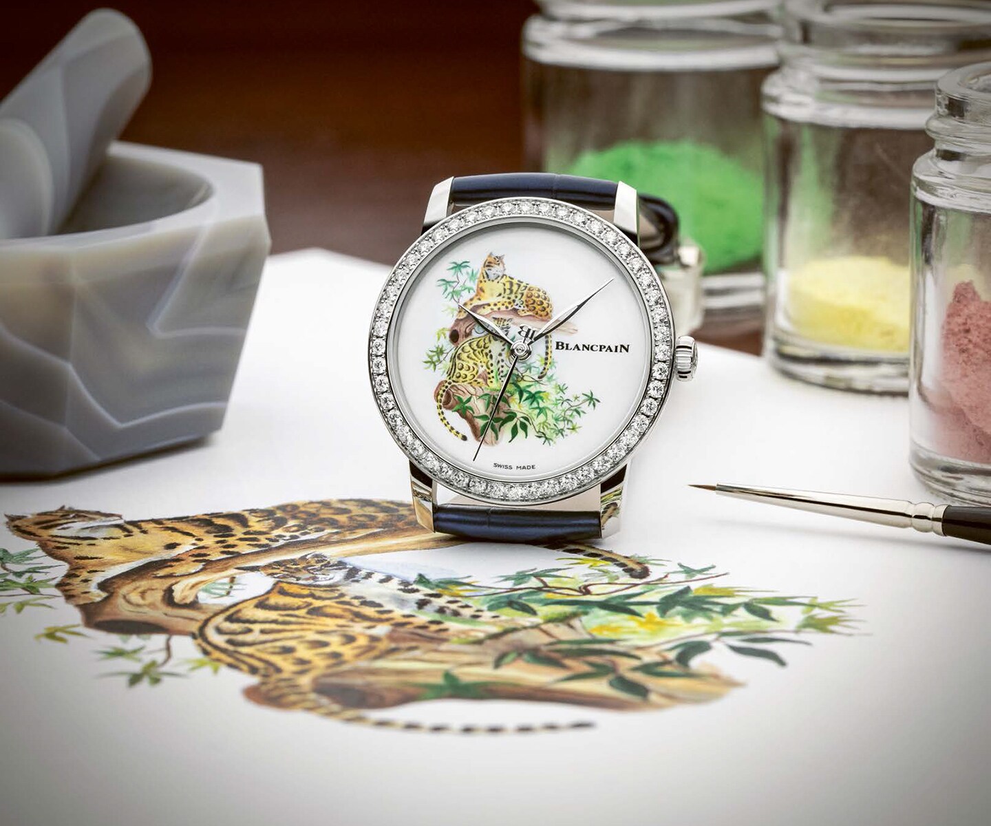 The clouded leopard in enamel-painted porcelain is framed by a 33 mm white gold case with a diamond-set bezel.
