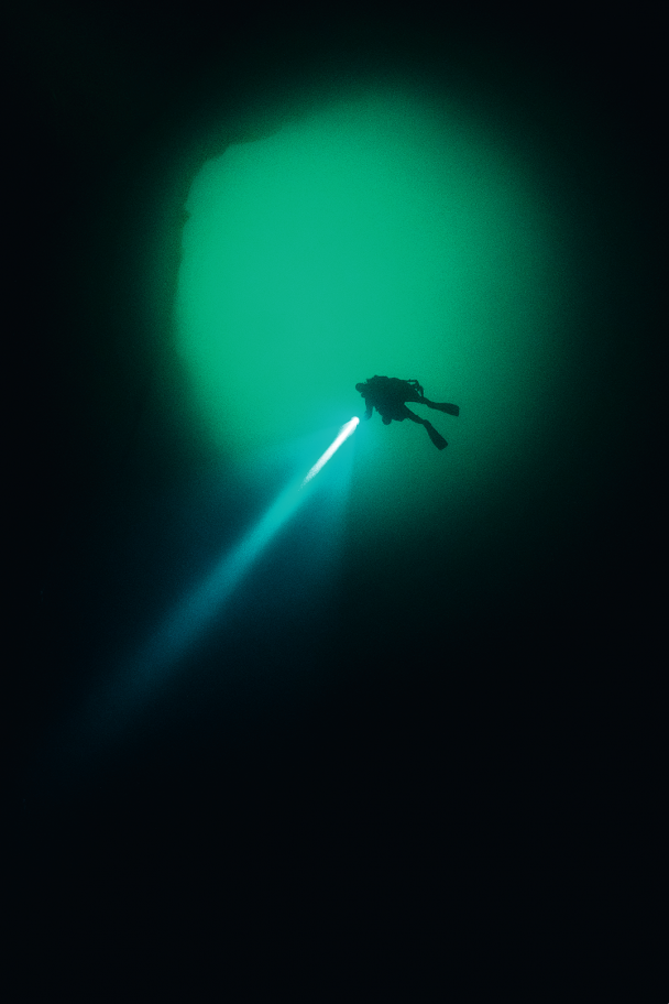 ベスビオ山のふもと、ナポリの海岸からわずか2キロほど離れた海底に、研究者たちが「ナポリのブラックホール」と呼んでいる洞穴がある。ゴンベッサ チームは、元はマグマ溜まりであったと思われるその場所の初の探査を実施した。水深50メートルの泥状の海底に、直径12メートルほどの入り口がある。穴は、完全な円筒形で垂直にのびているが、水深75メートル地点で急に広くなり、壁がどこにあるかわからなくなるほど大きな空間になっていることを発見。この垂直の洞窟は、巨大なワインのカラフェのような形をしており、水深96メートルでようやく底に到達した。
