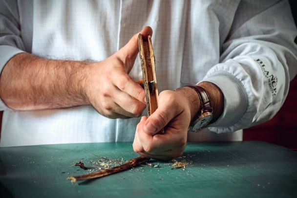 Disposti in fila bulini, utensili di legno e genziana utilizzati nel processo di anglage in più fasi.