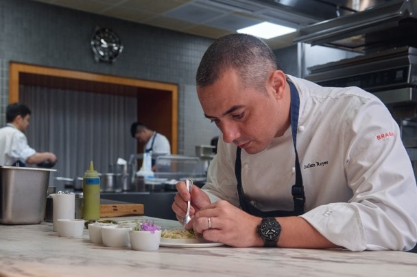 Chef Julien Royer rifinisce un anello di granchio marrone.